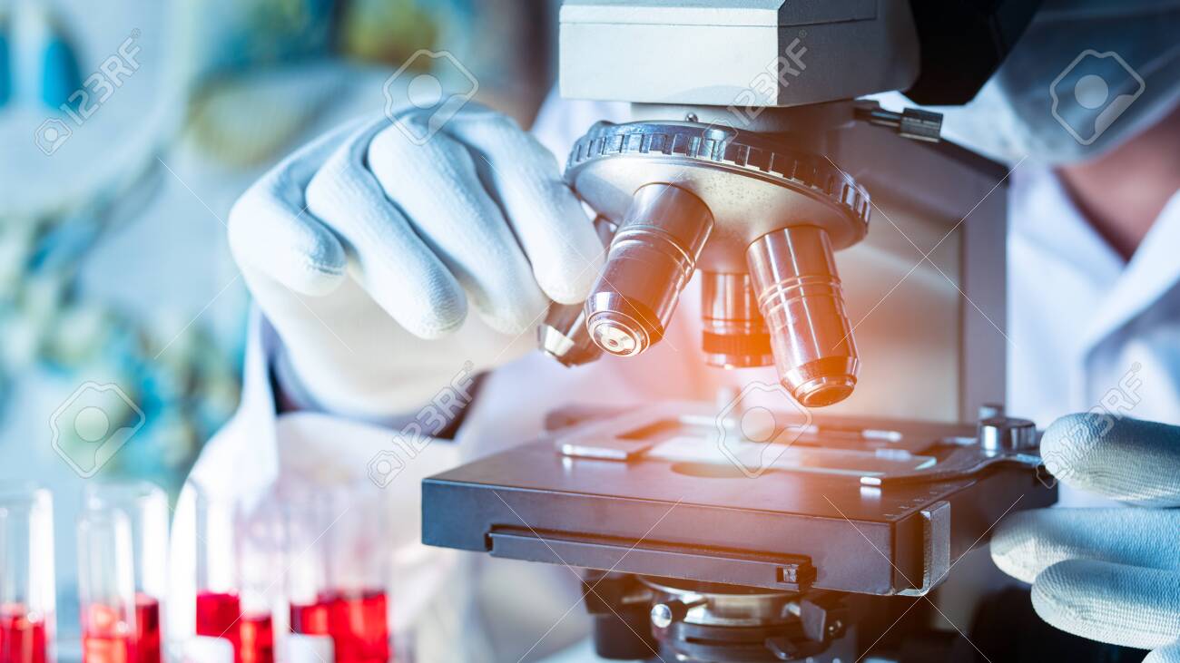 Lab technician performing DNA analysis under a microscope for court-admissible testing