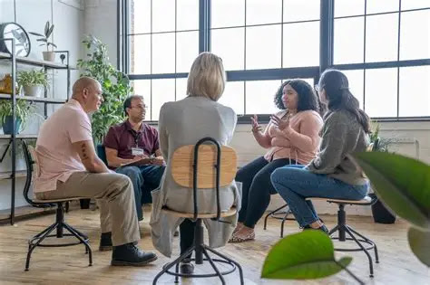 Small group of adults sharing in a bright, welcoming therapy room